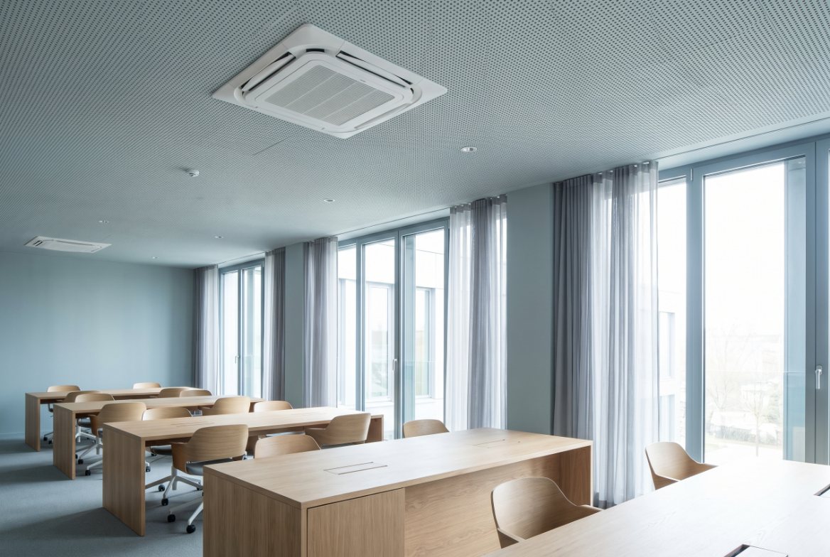 Modern kantoor met een plafondcassette van een airco in een akoestisch plafond